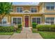 Charming two-story townhome with red door, white picket fence, and lush landscaping at 2614 Lodi Cir # 106, Kissimmee, FL 34746