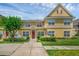 Charming two-story townhome with red door, white picket fence, and lush landscaping at 2614 Lodi Cir # 106, Kissimmee, FL 34746