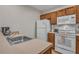 Well-equipped kitchen featuring white appliances, oak cabinets, and modern fixtures at 2614 Lodi Cir # 106, Kissimmee, FL 34746