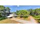 Aerial view of a charming two-story home with brick driveway, mature trees and lush greenery around the property at 2652 N Woodland Blvd, Deland, FL 32720