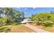 Aerial view of a charming two-story home with brick driveway, mature trees and lush greenery around the property at 2652 N Woodland Blvd, Deland, FL 32720