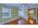Bedroom with adjacent bathroom featuring hardwood floors, ceiling fan, and natural light from windows at 2652 N Woodland Blvd, Deland, FL 32720