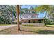 Charming two-story home features a covered porch and carport, nestled amid lush greenery and mature trees at 2652 N Woodland Blvd, Deland, FL 32720