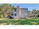 A two-story home with a chimney and a covered area, surrounded by a green lawn at 2652 N Woodland Blvd, Deland, FL 32720