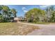 Charming two-story home with a long driveway and a covered parking area on a sunny day at 2652 N Woodland Blvd, Deland, FL 32720