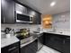 Modern kitchen with dark cabinets, stainless steel appliances, and granite countertops at 2798 Club Cortile Cir # A, Kissimmee, FL 34746