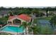 Community center pool area with pool, lounge chairs, palm trees, tennis courts, and manicured landscaping at 2798 Club Cortile Cir # A, Kissimmee, FL 34746