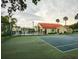 Community tennis court and pool view with lounge chairs, palm trees and beige buildings in background at 2798 Club Cortile Cir # A, Kissimmee, FL 34746