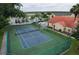 Community tennis court and pool view with lounge chairs, palm trees, and community beige buildings at 2798 Club Cortile Cir # A, Kissimmee, FL 34746