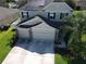 Aerial view of a two-story home with solar panels and a two-car garage at 3003 Cobham Rd, Kissimmee, FL 34758