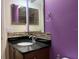 Bathroom vanity featuring a dark countertop, mosaic backsplash, and purple accent wall at 3003 Cobham Rd, Kissimmee, FL 34758