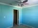 Turquoise bedroom features a ceiling fan, closet, and electrical outlets at 3003 Cobham Rd, Kissimmee, FL 34758
