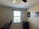 Cozy bedroom with neutral walls, a window, and a ceiling fan with a mini fridge at 3003 Cobham Rd, Kissimmee, FL 34758