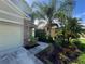 Well-maintained front yard with a walkway leading to the entrance, lush landscaping, and a large palm tree at 3003 Cobham Rd, Kissimmee, FL 34758