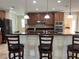 Spacious kitchen area features granite bar, stainless appliances, wooden cabinets and pendant lighting at 3003 Cobham Rd, Kissimmee, FL 34758