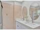 Bathroom features a marble vanity with double sinks, large, round mirrors, and updated tiling at 3134 Koval Ct, Orlando, FL 32837