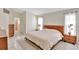 Well-lit bedroom with wood furniture, neutral bedding, and tiled flooring flowing into the ensuite bathroom at 3134 Koval Ct, Orlando, FL 32837