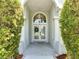 Welcoming front entrance with a glass double door framed by columns and lush greenery, offering curb appeal at 3211 Countryside View Dr, St Cloud, FL 34772