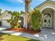 Beautiful home featuring a manicured lawn, mature landscaping, and an arched entry leading to the front door at 3211 Countryside View Dr, St Cloud, FL 34772