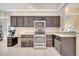 The kitchen features stainless steel appliances, dark cabinets, granite countertops, and tile flooring at 3211 Countryside View Dr, St Cloud, FL 34772
