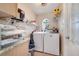 Bright laundry room featuring a window, washer, dryer, and wire shelving at 3211 Countryside View Dr, St Cloud, FL 34772