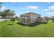 Expansive backyard with lush green grass, a covered patio, and a well-maintained exterior at 3629 Sublett Loop, Tavares, FL 32778