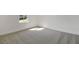 An empty bedroom with new gray carpeting and a window that brings sunlight into the room at 3629 Sublett Loop, Tavares, FL 32778