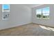 Bright bedroom with wood-look flooring and natural light from the two windows at 3629 Sublett Loop, Tavares, FL 32778