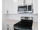 Modern kitchen featuring stainless steel appliances, white cabinets, and tile backsplash at 3629 Sublett Loop, Tavares, FL 32778