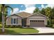 Charming single-story home with stone accents, manicured lawn and an attached two-car garage at 3645 Sublett Ave, Tavares, FL 32778