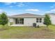Backyard featuring a patio, sliding glass doors, young trees, and an exterior AC unit at 4071 Bannock Ave, Tavares, FL 32778