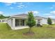 View of the backyard with a covered patio and sliding glass doors to the home's interior at 4071 Bannock Ave, Tavares, FL 32778