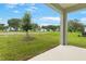 Serene backyard view showcasing a well-maintained lawn, young trees, and distant water feature at 4071 Bannock Ave, Tavares, FL 32778