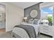 Serene bedroom with a gray accent wall, round mirror, and bright window for a peaceful and stylish atmosphere at 4071 Bannock Ave, Tavares, FL 32778