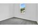 Cozy bedroom featuring plush carpeting, bright white walls, and a large window with exterior view at 4071 Bannock Ave, Tavares, FL 32778