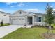 Charming single-story home featuring a manicured lawn, stone accents, and a two-car garage at 4071 Bannock Ave, Tavares, FL 32778