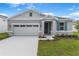 Charming single-story home featuring a manicured lawn, stone accents, and a two-car garage at 4071 Bannock Ave, Tavares, FL 32778