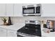Stainless steel microwave and oven over a stovetop in a bright, modern kitchen at 4071 Bannock Ave, Tavares, FL 32778