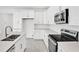Modern, all-white kitchen featuring an island, stainless steel appliances, and ample counter space at 4071 Bannock Ave, Tavares, FL 32778