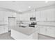 Modern, all-white kitchen featuring an island, stainless steel appliances, and ample cabinet space at 4071 Bannock Ave, Tavares, FL 32778