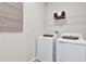 Functional laundry room with a modern washer, dryer, and shelving, providing an organized space for laundry tasks at 4071 Bannock Ave, Tavares, FL 32778