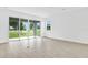 Bright, airy living room featuring wood-look tile flooring and sliding glass doors with backyard view at 4071 Bannock Ave, Tavares, FL 32778