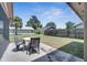 Back yard with a table and chairs on a concrete patio and a partial view of the fence at 42 Chip Ct, Kissimmee, FL 34759