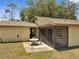 Back patio with table and chairs along with screen enclosure on a manicured lawn at 42 Chip Ct, Kissimmee, FL 34759