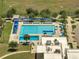 An aerial view of a neighborhood pool area with lap lanes, diving board, shaded seating, and mature landscaping at 42 Chip Ct, Kissimmee, FL 34759
