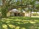 Inviting single-story home featuring a well-manicured lawn and mature shade tree at 42 Chip Ct, Kissimmee, FL 34759