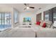 Cozy living room with ceiling fan and large windows, featuring a comfortable reclining sofa at 42 Chip Ct, Kissimmee, FL 34759