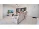 Open living room with tile floors, featuring a large sofa, TV, and ample natural light at 42 Chip Ct, Kissimmee, FL 34759