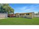 Spacious backyard featuring a covered patio, lawn, and storage shed at 4218 Drexel Ave, Orlando, FL 32808