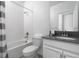 Neutral bathroom with shower over bath, grey countertop, and bright white tile and cabinets at 4290 Paragraph Dr, Kissimmee, FL 34746